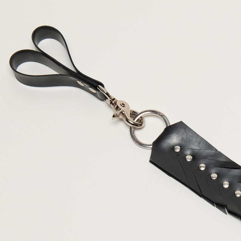 Black rubber finger loops with feathered design and metal accents on a light gray background