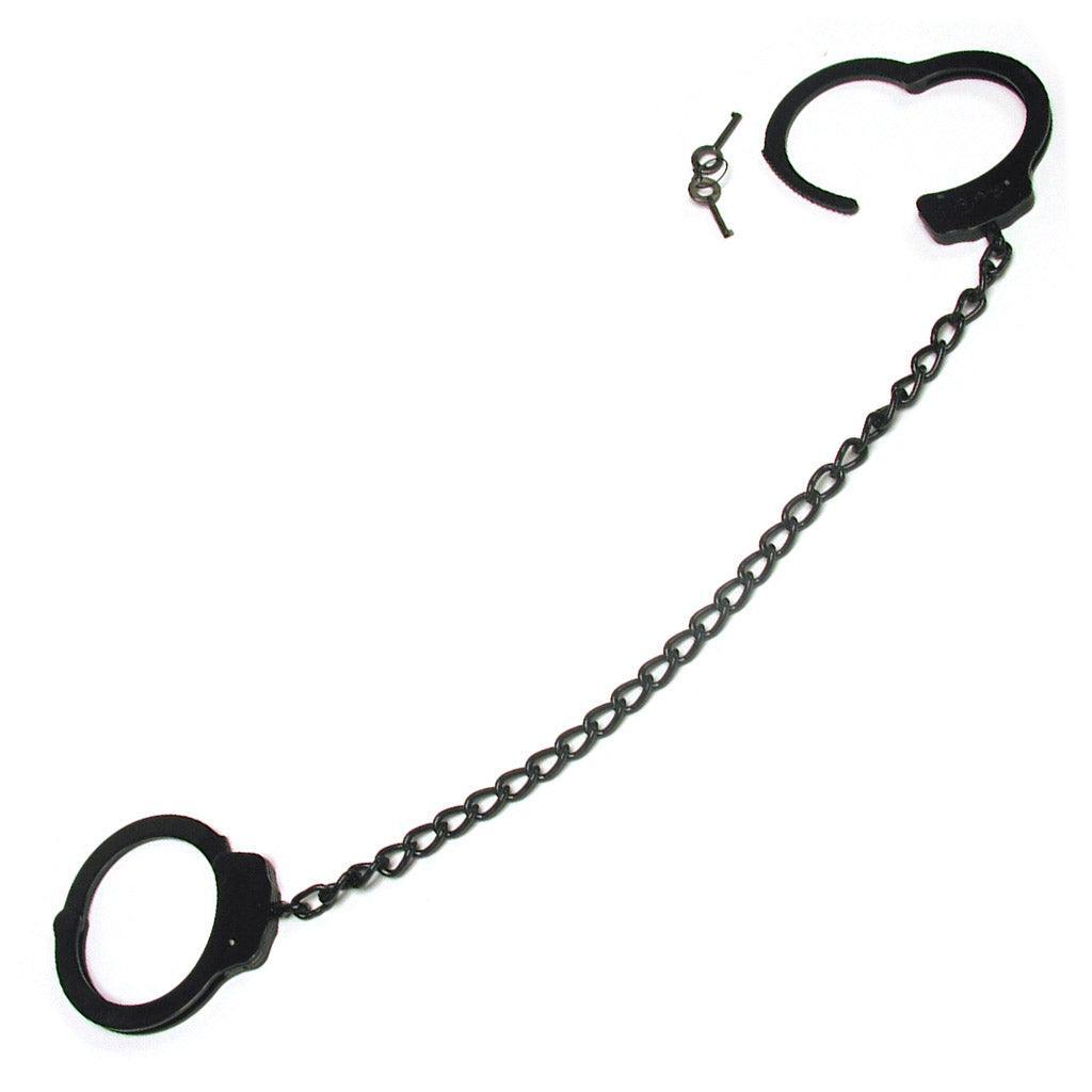 A pair of black metal leg cuffs, joined by a long chain. A pair of keys sits to the side.