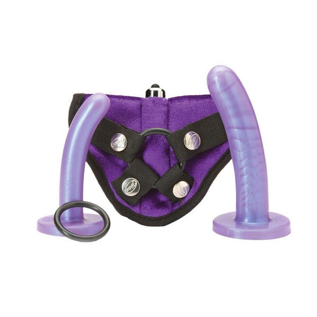 The Tantus Bend Over Harness Kit is shown against a blank background. It has a strap-on made of purple fabric with a pocket for a bullet vibrator, two slightly curved light purple dildos, one smaller than the other, and an extra silicone O-Ring.