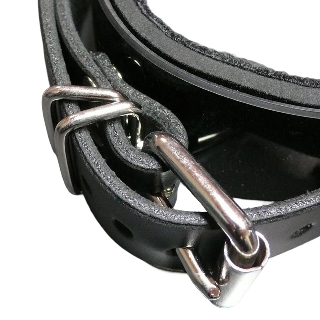 A close-up of the buckling strap of the Half Moon Bit Gag By Scott Paul Designs is shown on a grey table.