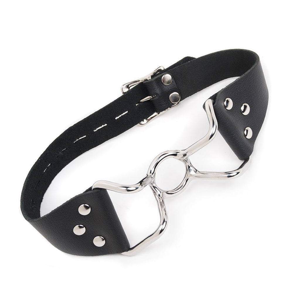 The Spider Gag is shown against a blank background. It is made of a silver metal O-ring in the center with protruding metal handles on each side. A black leather strap connects to the gag's handles.