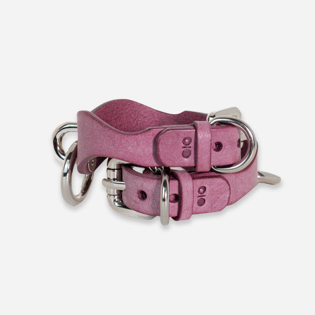 Side view of a pair of BDSM wrist cuffs in lavender leather. The angle shows off the adjustable fastening point.