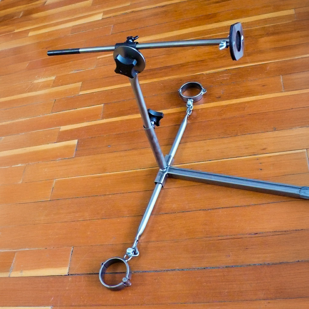 The lower half of the Stockroom Stockade, positioned on a wooden floor, is shown. There are twistable handles to adjust the depth of the fucking rod.
