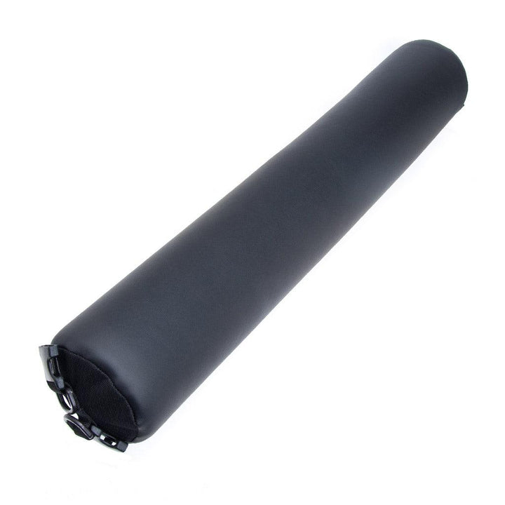 The Talea Spreader Bar By Liberator is displayed against a blank background. It is a thick bolster pillow with a black leather exterior with two plastic D-rings on each end.