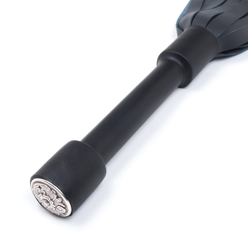 A close-up of the Blue Devil Leather Flogger By Dragontailz handle is displayed against a blank background, showing the silver ornamental cap on the end of the handle.