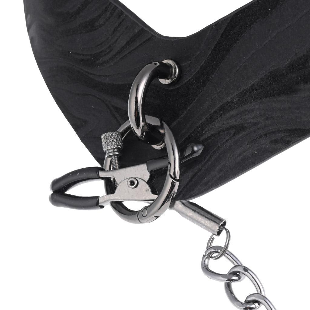Close-up of the main attachment point of the Velvet Noir collar, showing the nipple clamps beginning to be threaded through it.