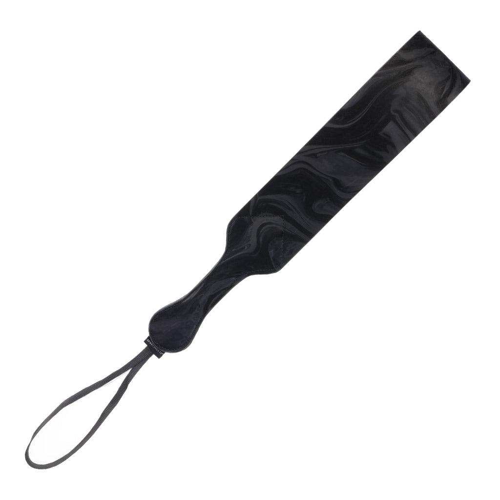 Product shot on a white background. The Velvet Noir Paddle is a loop of vegan faux-leather with a marbled pattern on it.