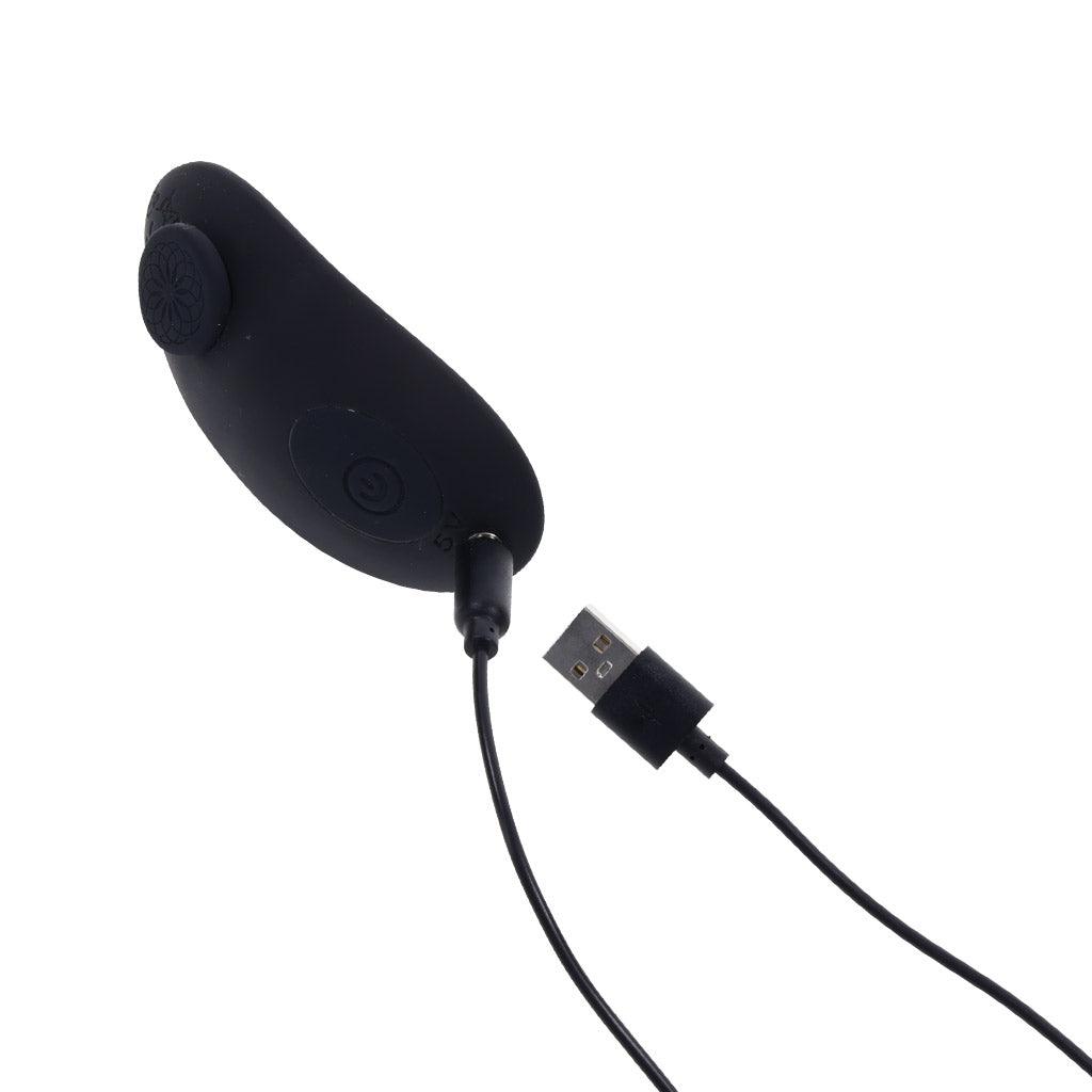The vibrator seen from a top angle with the USB recharging cord inserted.