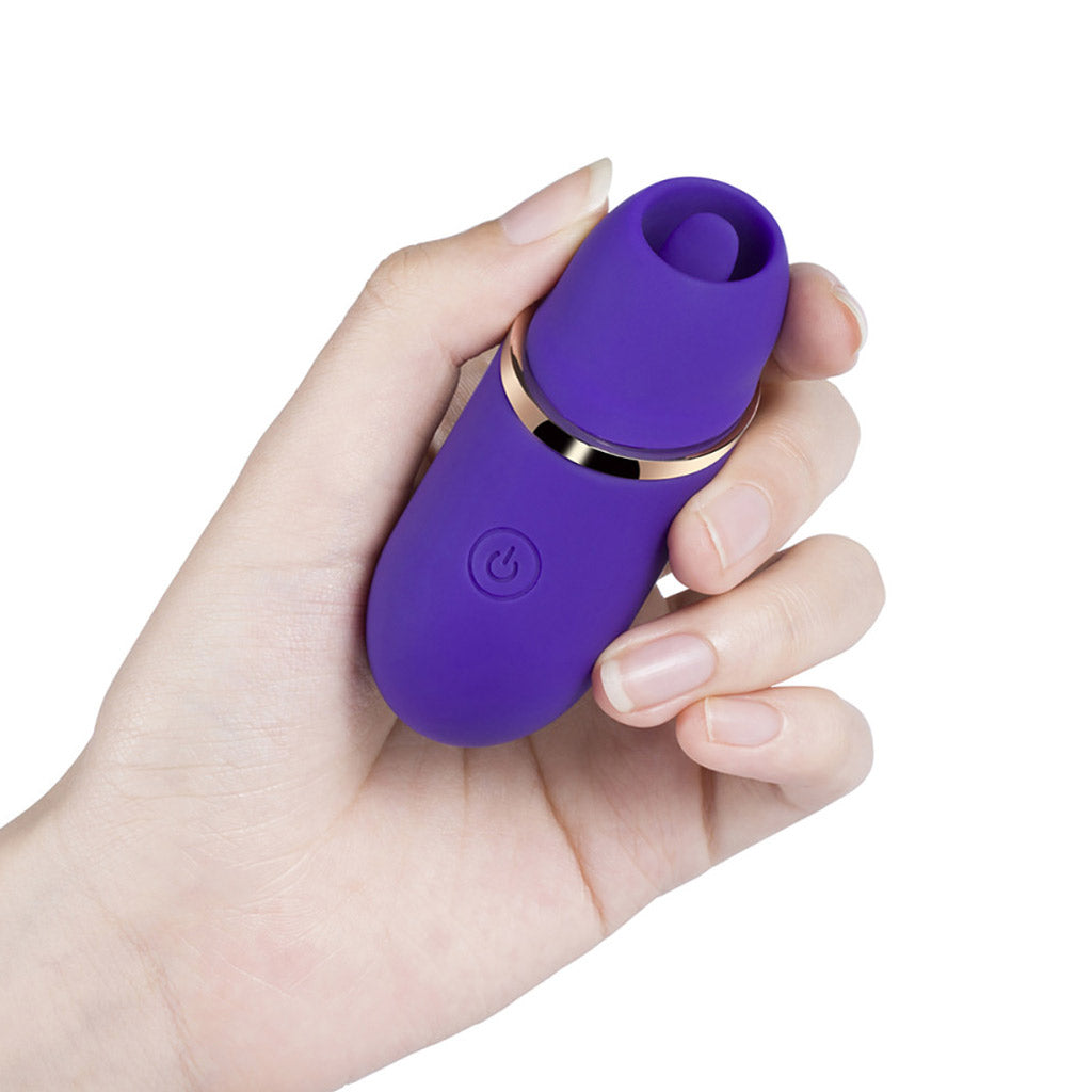 A person's hand holding the purple model of the mini clit licking vibe.