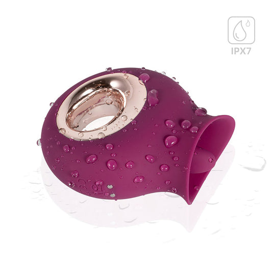 The Alvina Tongue Vibrator lying on its side, covered with beads of water. In the upper left corner, there's a water graphic with text: "IPX7"
