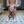 Load image into Gallery viewer, A nude woman is shown from behind, kneeling on an ornate bathroom floor and hanging her head. She is locked in the X-Bars Spreader, and her hands are clasped behind her back.

