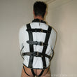 Load image into Gallery viewer, A man wearing the white Premium Leather Straitjacket is shown from behind. The jacket is made of white leather with black straps.