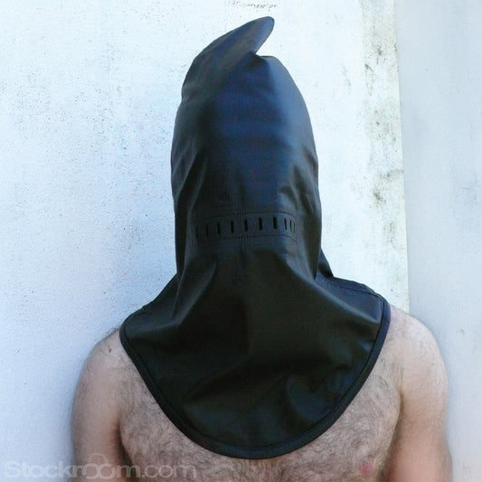 The Leather Guillotine Hood is shown on a man with dark chest hair standing in front of a white wall. The hood fits loosely and has a point at the top and a U-shaped bottom that reaches his chest.