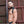Load image into Gallery viewer, A man stands sideways in front of a metal wall, wearing the Combat Leather Harness. The harness covers the tops of the shoulders and wraps under the arms, buckling in front of the arm and in back.
