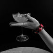 Load image into Gallery viewer, A woman’s forearm rests against a table and her hand is outstretched, holding a cocktail glass. The image is in black and white except for the Melanie Rose Designs x The Stockroom wrist cuff she is wearing.