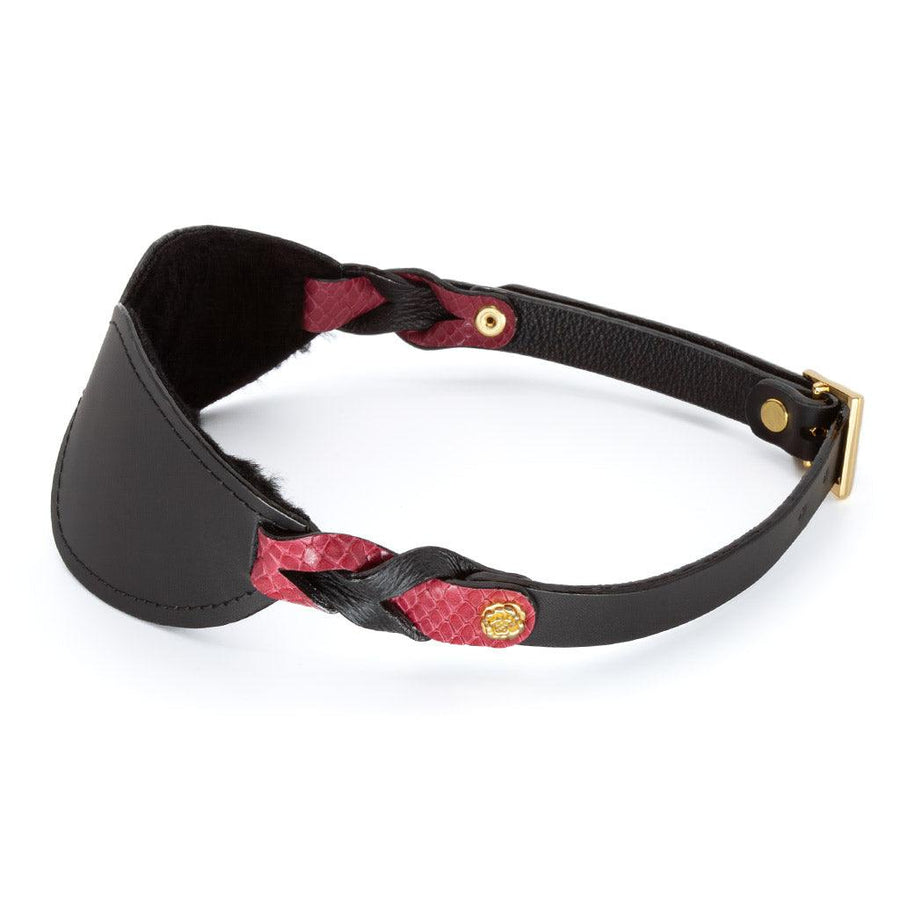  The Melanie Rose Designs x The Stockroom Blindfold, a black leather blindfold with straps made of braided black and red leather, is displayed against a blank background.