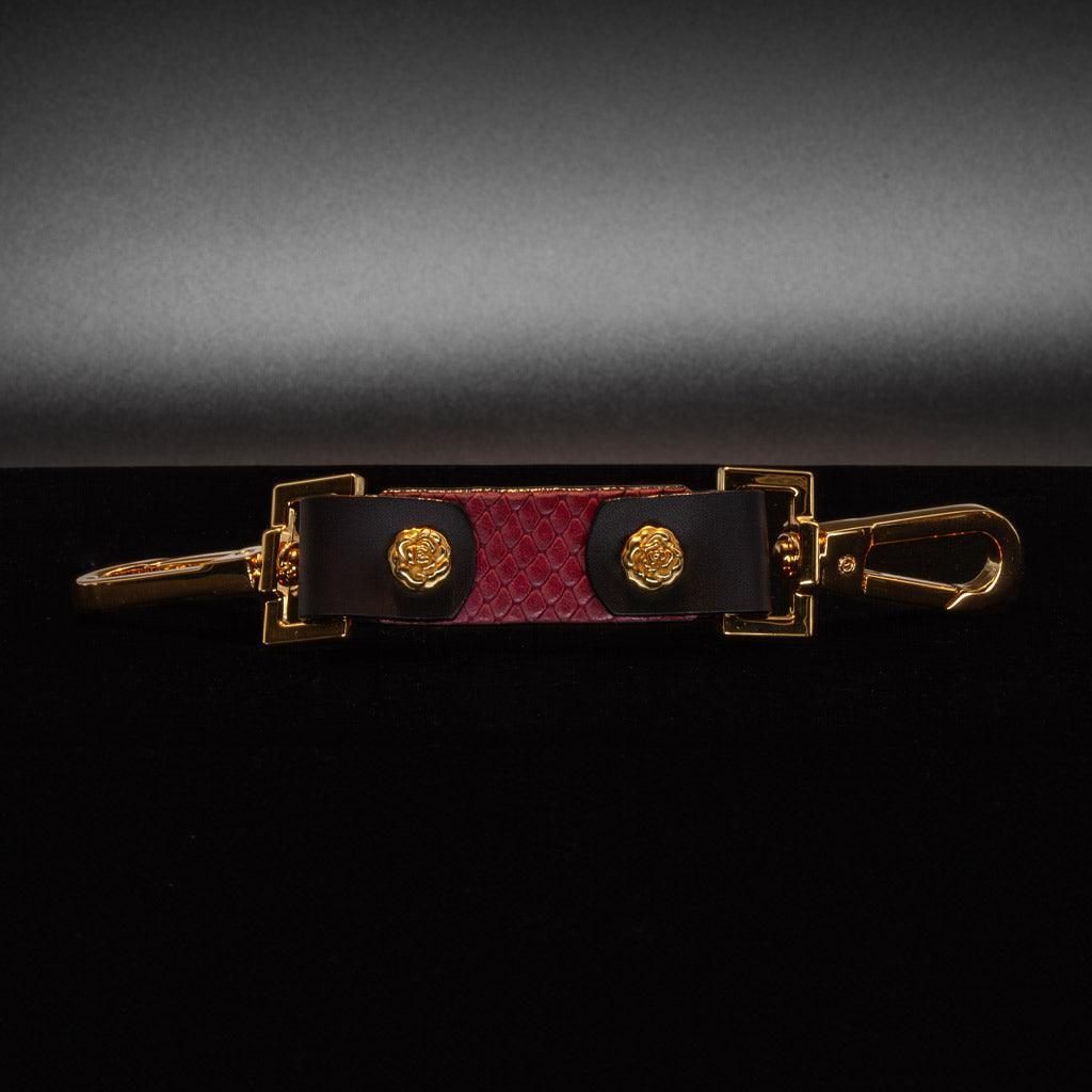 The Melanie Rose Designs x The Stockroom Restraint Clip is displayed against a black background.