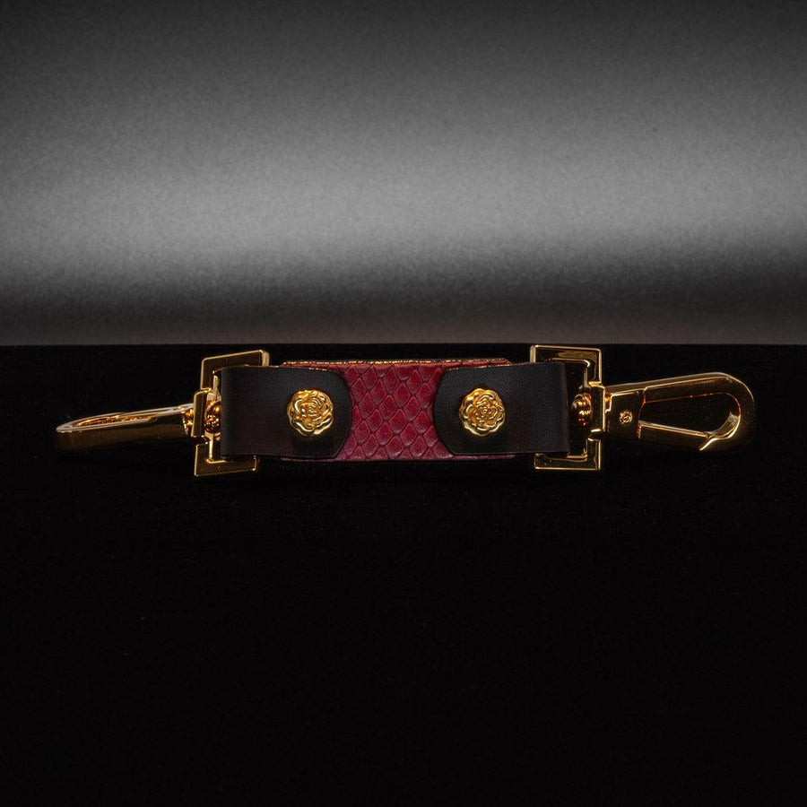 The Melanie Rose Designs x The Stockroom Restraint Clip is displayed against a black background. 