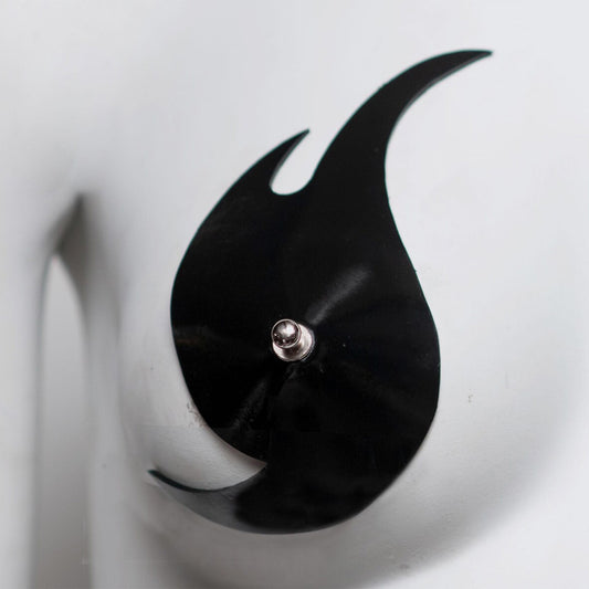 Close up of black flame shaped nipple pastie on a white background
