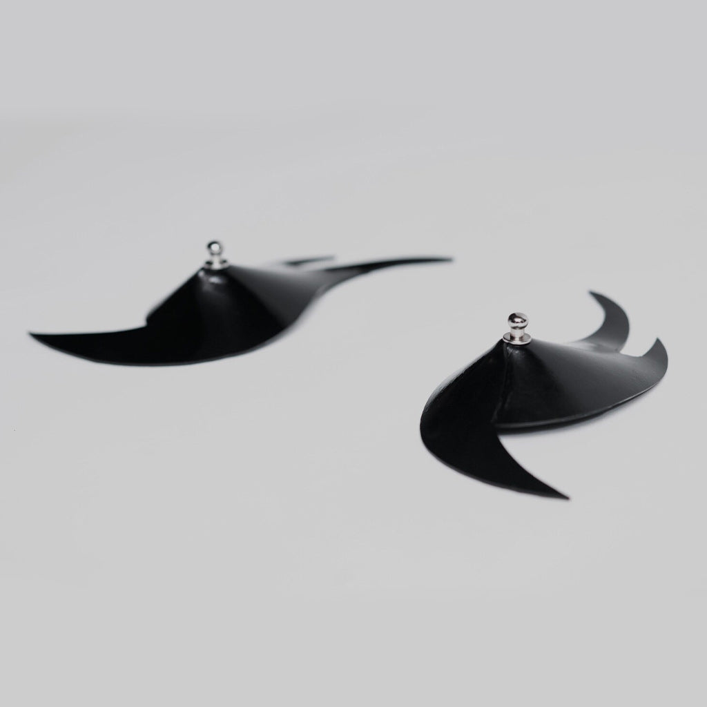 Black flame-shaped pasties on a light background