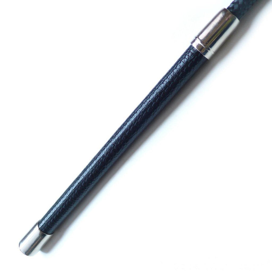 A closeup of the rod of the Black Leather Wide End Riding Crop is shown against a blank background. The rod is covered and black leather with two silver metal caps on each end.