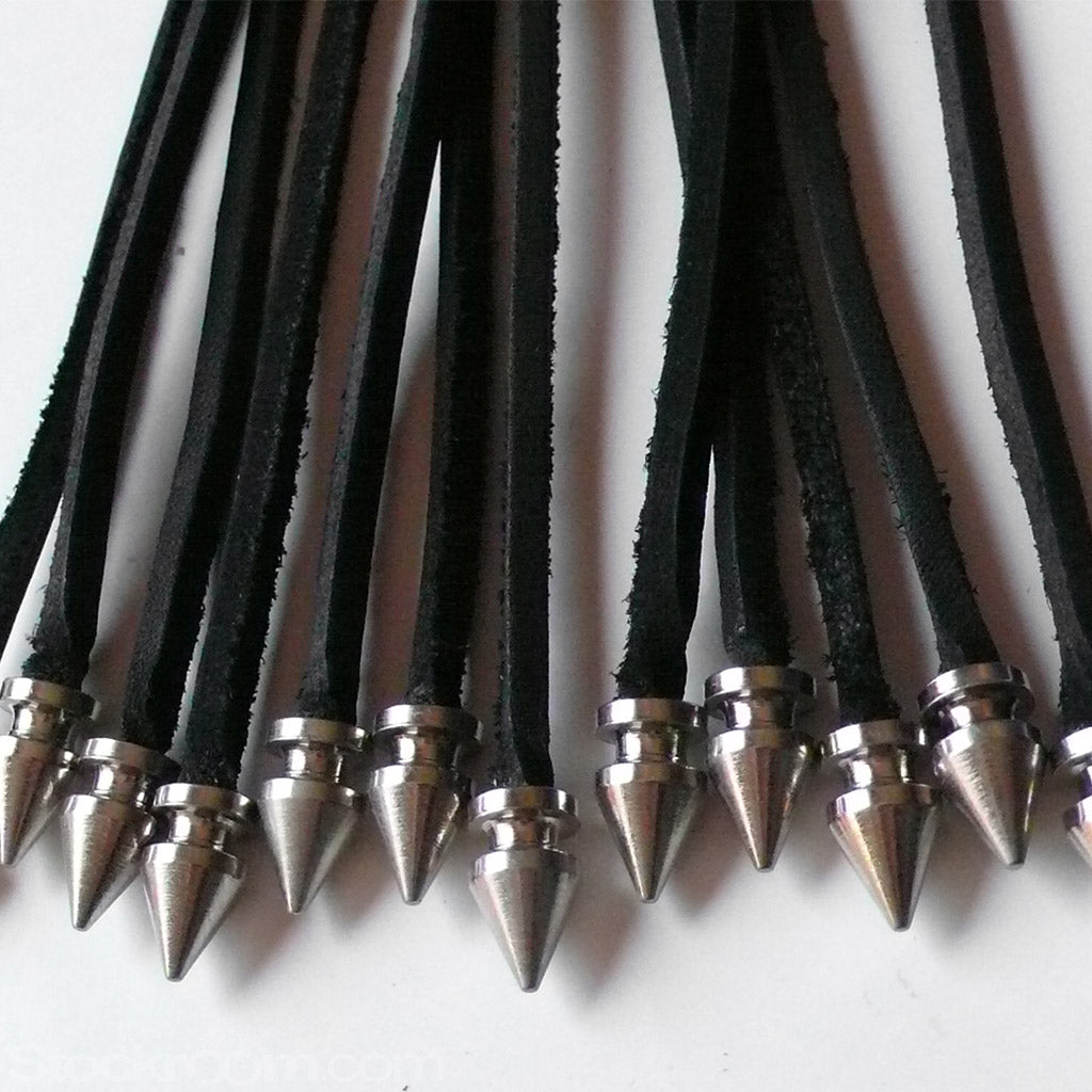 A close-up of the tips of the falls of the black leather 20-inch Thong Whip with Spiked Tails is displayed against a blank background.