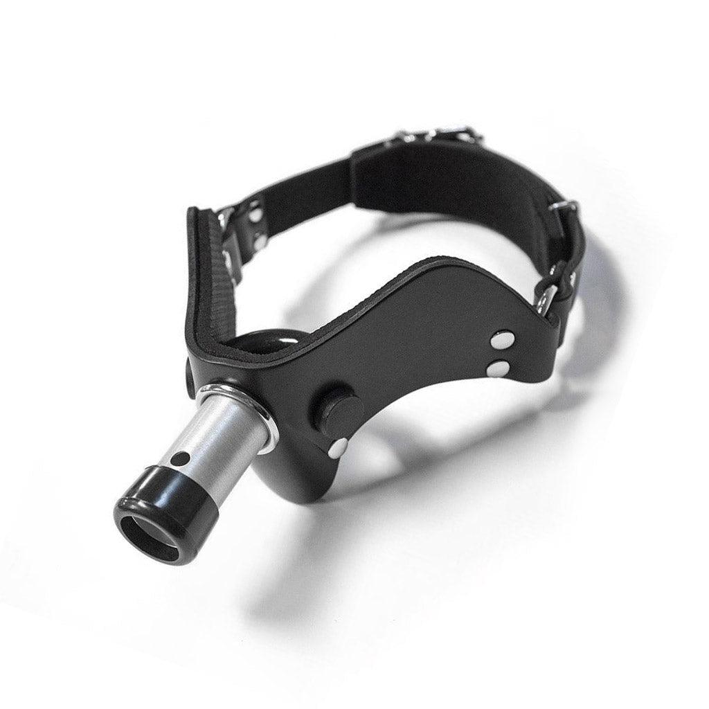 The “How May I Help You?” Gag, A.K.A the Humiliator Gag, is displayed against a blank background. The gag has a padded, black leather V-shaped front with a rounded bit on the inside. A short metal rod protrudes from the center of the gag.