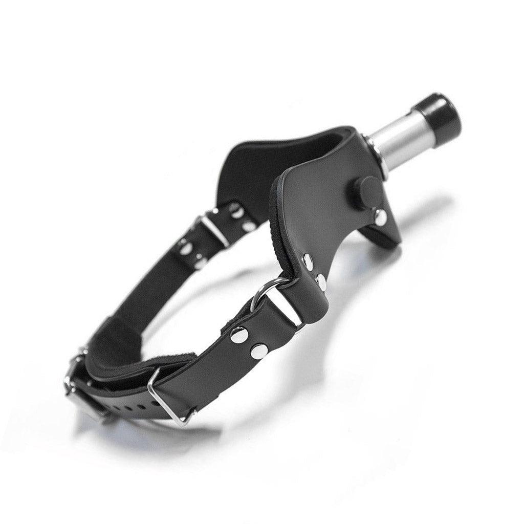 The “How May I Help You?” Gag, A.K.A the Humiliator Gag, is displayed against a blank background. The gag has an adjustable buckling strap with silver hardware.