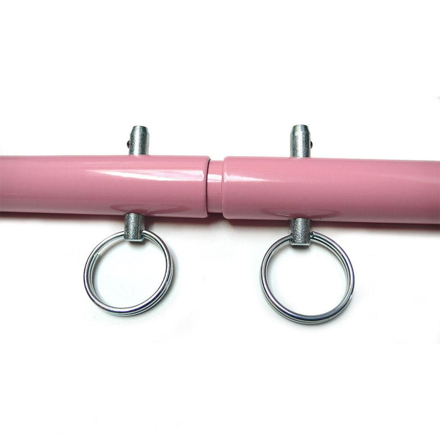 A closeup of the metal pegs on the Pink Adjustable Spreader Bar is shown against a blank background.