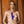 Load image into Gallery viewer, A naked blonde woman is shown from the waist up against a wooden background. She is holding the Jack Rabbit Signature Silicone Thrusting Rabbit between her breasts.
