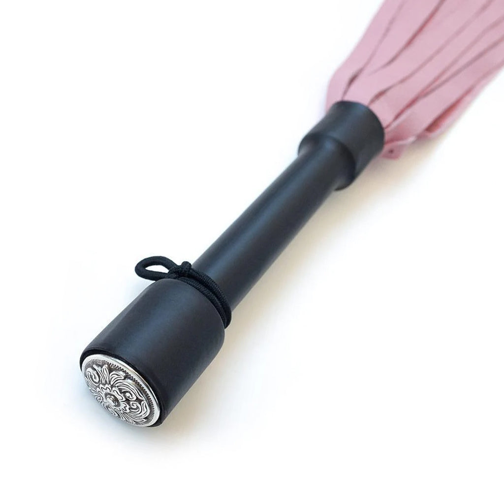 A close-up of the Pink Devil Leather Flogger By Dragontailz handle is displayed against a blank background, showing the silver ornamental cap on the end of the handle.