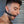 Load image into Gallery viewer, A close-up of a dark-haired man’s face is shown. He has some facial stubble and is wearing a metal hoop earring. He stands in front of a metal wall, looking down, and is wearing the Silicone O-Ring Bondage Mouth Gag.
