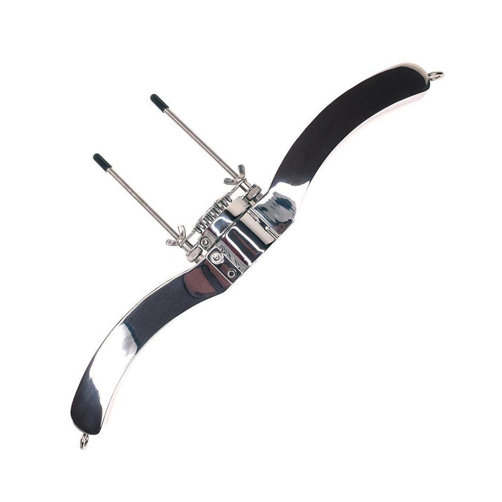 The Ze Ultimate Humbler Stainless Steel Lockable Ball Pillory is displayed against a blank background. In the middle is a slightly curved piece of metal with 2 thin, long metal bolts on top. On each side of the middle piece is a curved, longer piece of metal.