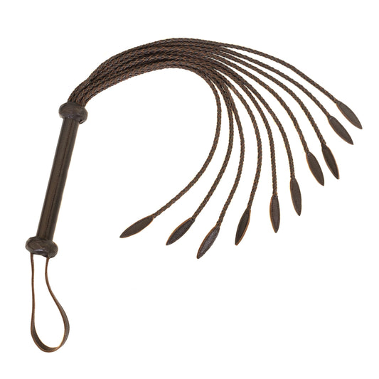 The Brown Leather Braided Whip is shown against a blank background. The falls of the whip are made of thin pieces of leather braided together with a wider tear-drop shape at the end. The handle is made of brown leather and has a wrist loop at the base.