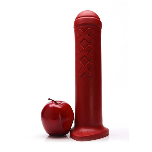 The red Tantus Amsterdam XL Silicone Dildo is shown next to a red apple against a white background.
