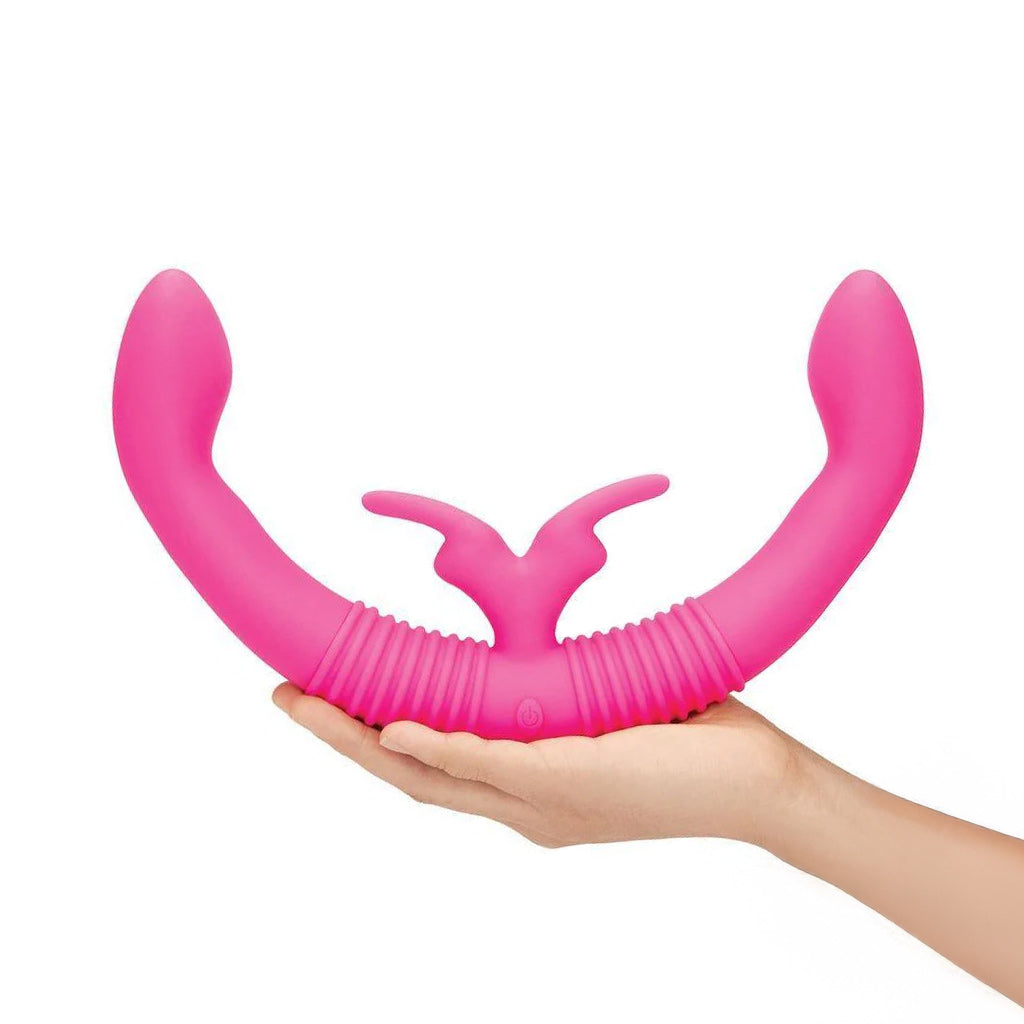 The together™ Couples Vibrator is heald by a extended hand in front of a white background.