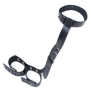 The Leather Neck-Wrist Restraint is displayed against a blank background. It is made of black leather and consists of a collar with a leather strap coming down from it. The strap of leather has two cuffs at the end. The collar, strap, and cuffs are adjustable.