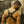 Load image into Gallery viewer, A muscular man poses wearing the black Leather Chest Harness, facing away from the camera, as well as arm gauntlets and a black latex thong. The chest harness forms an X on his back with an O-ring in the center.
