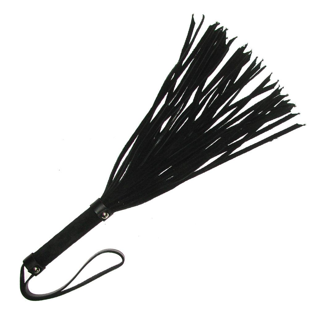 The 18" Basic Suede Flogger is displayed against a blank background. The falls and handle are made of black suede. There is a wrist strap made of black leather at the base of the handle.