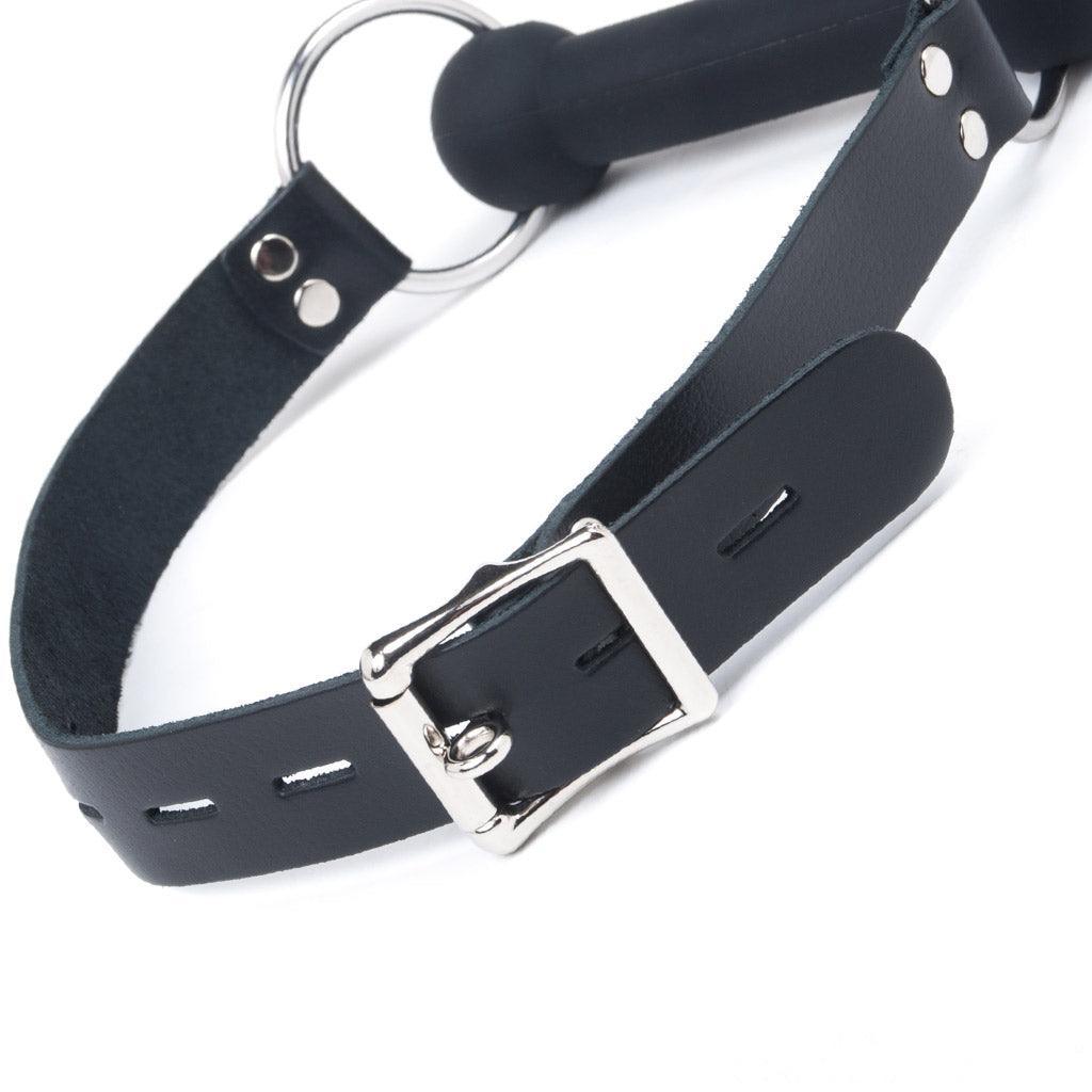 A close-up of the buckle from the Silicone Bit Gag is displayed against a blank background.