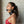Load image into Gallery viewer, A brunette woman is shown in profile in front of a white wall. She wears the black Leather Posture Collar with Silicone Ball Gag with a D-ring in front. The ball gag is in her mouth and is attached to the collar by a leather strap.
