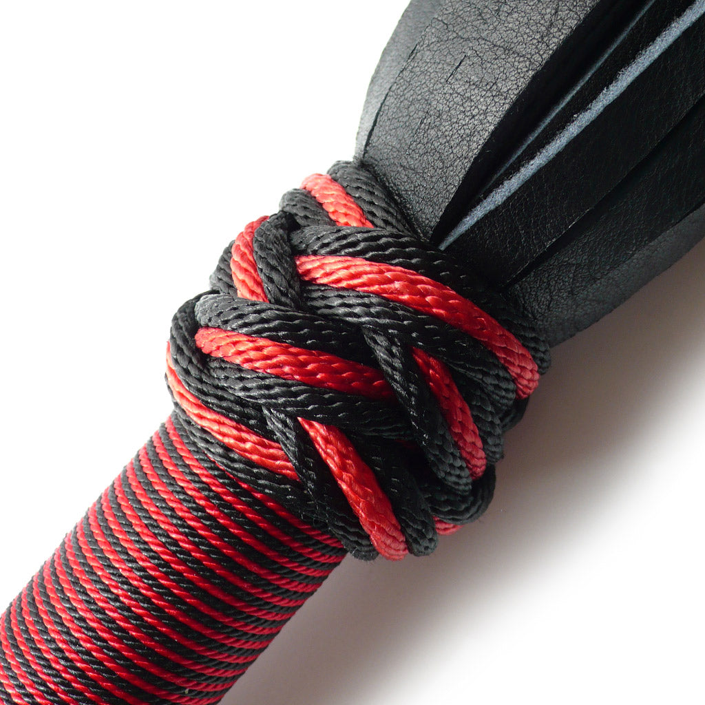 A close-up of the top of the red/black 30-inch Elk Hide Flogger handle is displayed against a blank background.