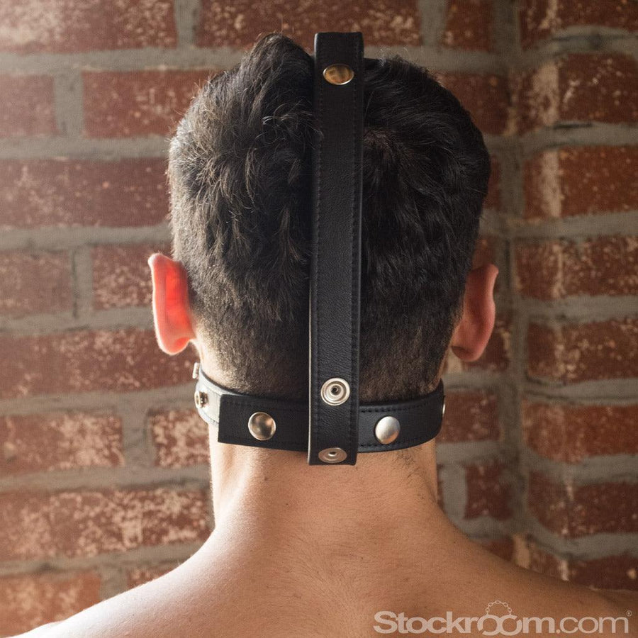 The back of a man's head is shown in the Head-On BDSM Gag Harness. One leather strap runs down the middle of his head and loops around another strap running horizontally around his neck.