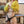 Load image into Gallery viewer, A woman with red hair in a yellow sweater is shown wearing the Veronica Strapon Harness with a black dildo attached. The harness is black with small white polka dots.
