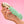 Load image into Gallery viewer, Somebody’s hand is shown holding up the Fun Factory Sundaze Pulsating Vibrator in Pistachio against a pink background.
