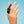 Load image into Gallery viewer, A person’s hand is shown holding the Fun Factory Be-One Couples Vibrator between their fingers against a light blue background.

