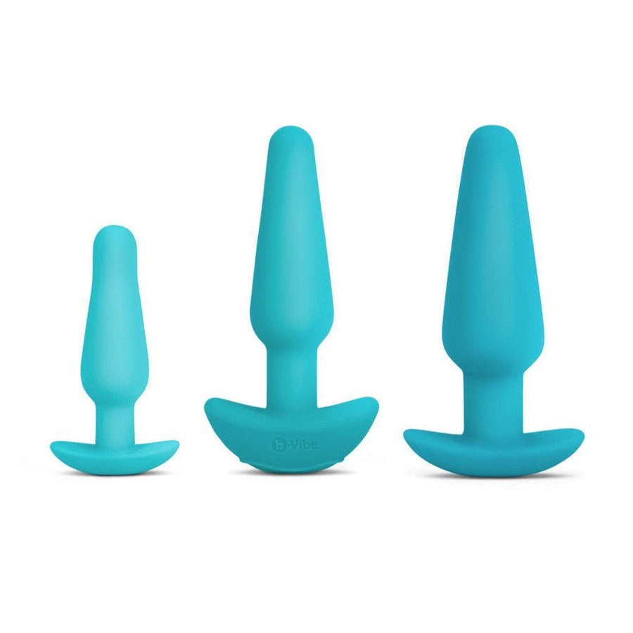 The three plugs from the b-Vibe Anal Training & Education Butt Plug Set in Aqua are shown against a blank background. The plugs are tapered with thin necks and flared, curved bases. They are arranged with the smallest on the left and largest on the right.