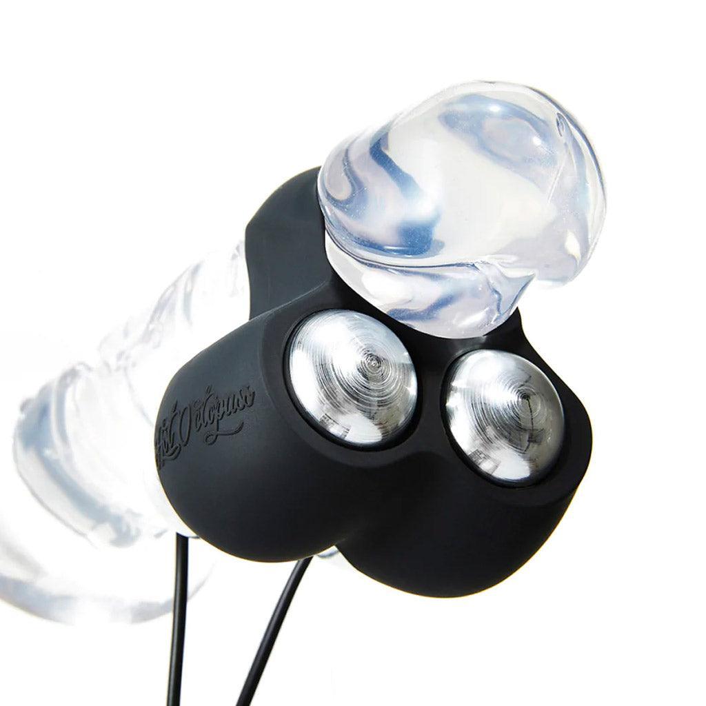 The cockring of the Hot Octopuss Jett Penis Vibrator is shown on a clear dildo. The cockring sits under the head with the vibrators against the frenulum.