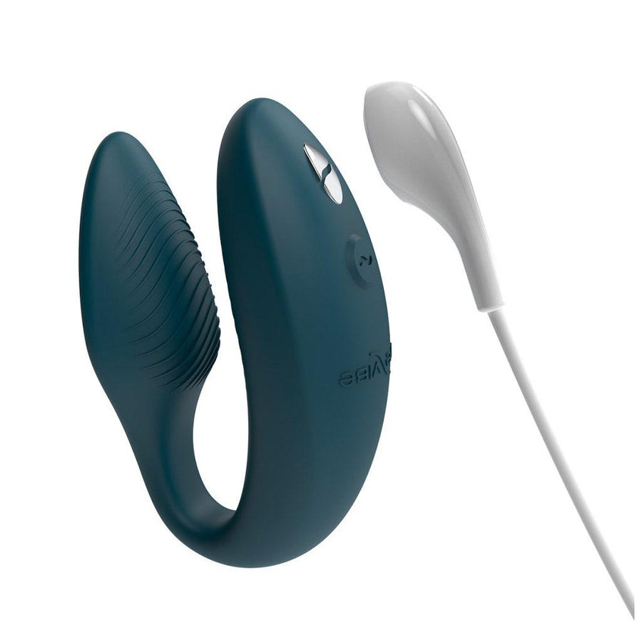 An image of the We-Vibe Sync 2 Couples Vibrator in the Green Velvet color on a plain white background. It is shown next to the included USB rechargeable cord.