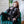 Load image into Gallery viewer, A woman with red hair sits with her legs spread on a velvet chair. She is wearing a sheer black blouse, black underwear, and black latex stockings. She is also wearing black Garment Leather Wrist Cuffs With Brass Gold Hardware and a matching collar.
